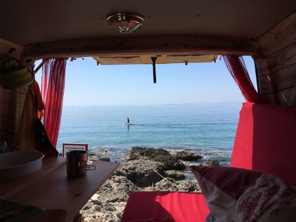 Vom Bus aus in Richtung Meer schauen. Jemand surft.