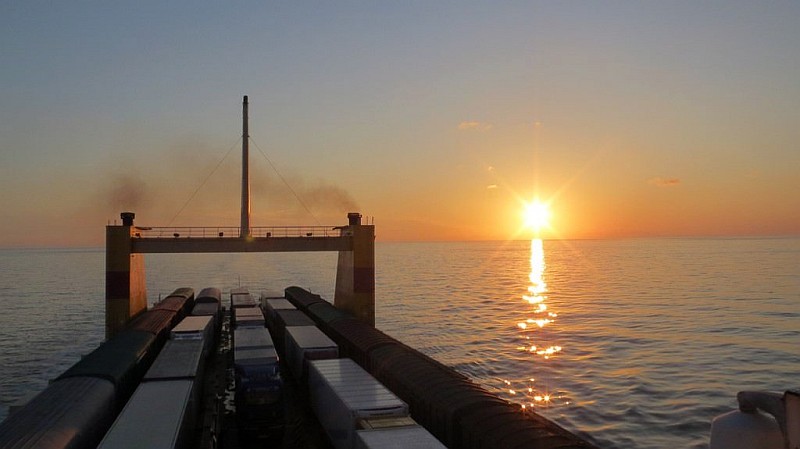 Frachtschiff in Meer mit Sonnenuntergang