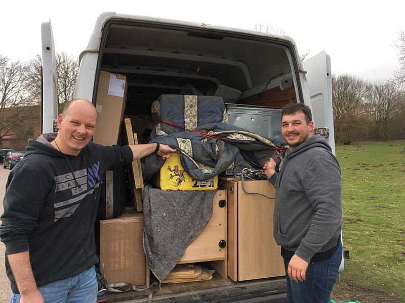 zwei Männer mit Möbeln in einem Lieferwagen